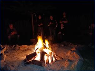 A group of people around a campfire

Description automatically generated